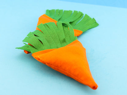 Catnip filled carrot shaped toy. Bright orange fabric with soft green leaves.